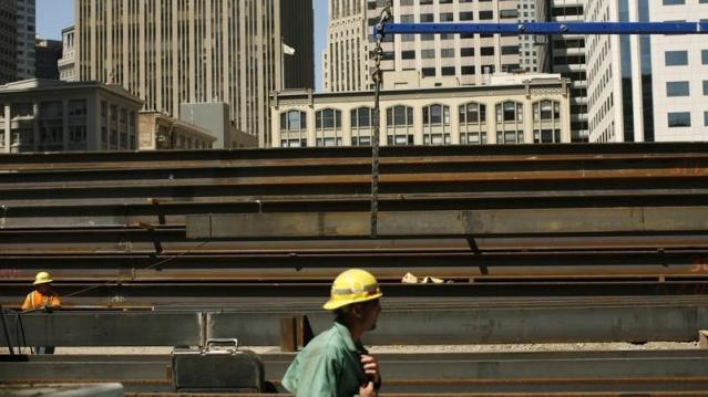 Workers guide steel beams into place at a construction site in San Francisco, California September 1, 2011.  REUTERS/Robert Galbraith  