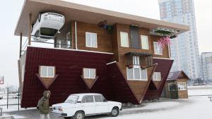 A man passes a house built upside-down in Russia's Siberian city of Krasnoyarsk