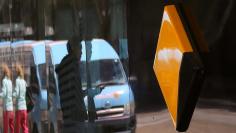 FILE PHOTO: Pedestrians are reflected in the window of a branch of the Commonwealth Bank of Australia (CBA), Australia's biggest bank by market value, in Sydney, Australia, November 8, 2017.     REUTERS/Steven Saphore/File Photo