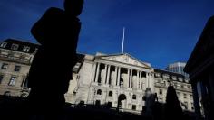 FILE PHOTO: A man is silhouetted as he walks past the Bank of England in the City of London, Britain, December 12, 2017. REUTERS/Clodagh Kilcoyne