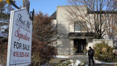 FILE PHOTO: A police forensics photographer works outside the home of billionaire founder of Canadian pharmaceutical firm Apotex Inc. in Toronto