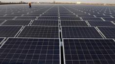 Worker walks among solar panels at a floating solar plant developed by China's Three Gorges Group, in Huainan