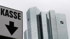 The cash desk sign of a nearby car park is pictured next to the head quarters of Germany's largest business bank, Deutsche Bank, in Frankfurt