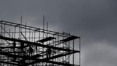 Workers are silhouetted on amongst scaffold at Potsdamer Platz square in Berlin, Germany, October 27, 2017. REUTERS/Fabrizio Bensch