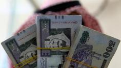 FILE PHOTO: A Saudi money changer displays Saudi Riyal banknotes at a currency exchange shop in Riyadh, Saudi Arabia September 29, 2016. REUTERS/Faisal Al Nasser/File Photo