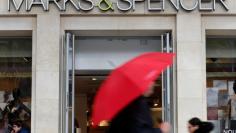 FILE PHOTO: Pedestrians walk past a Marks & Spencer store on the Champs Elysees avenue in Paris