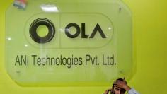 FILE PHOTO: An employee speaks over his phone as he sits at the front desk inside the office of Ola cab service in Gurugram