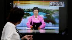 FILE PHOTO: People walk past a street monitor showing a news report about North Korea's nuclear test in Tokyo, Japan, September 3, 2017. REUTERS/Toru Hanai 