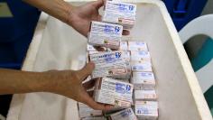 FILE PHOTO: A health worker shows unused packs of anti-dengue vaccine Dengvaxia at the Manila Health Department in Sta Cruz