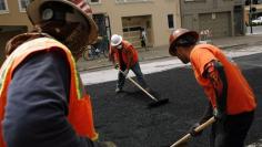 FILE PHOTO - Workers spread asphalt on a street in the Cow Hollow neighborhood in San Francisco, California June 2, 2010. REUTERS/Robert Galbraith