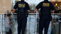 Homeland Security personnel keep watch as travelers depart at Lindbergh Field airport in San Diego, California, U.S. July 1, 2016. REUTERS/Mike Blake 