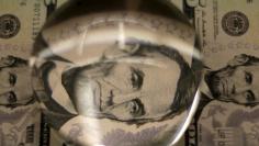 FILE PHOTO: Sheets of former U.S. President Abraham Lincoln on the five-dollar bill currency are inspected through a magnifying glass at the Bureau of Engraving and Printing in Washington March 26, 2015. REUTERS/Gary Cameron/File Photo                  