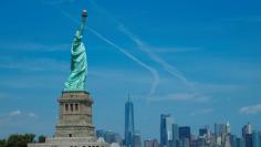 People visit the Liberty State Island as Lower Manhattan is seen at the background in New York