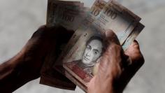 A man counts Venezuelan bolivar notes in downtown Caracas